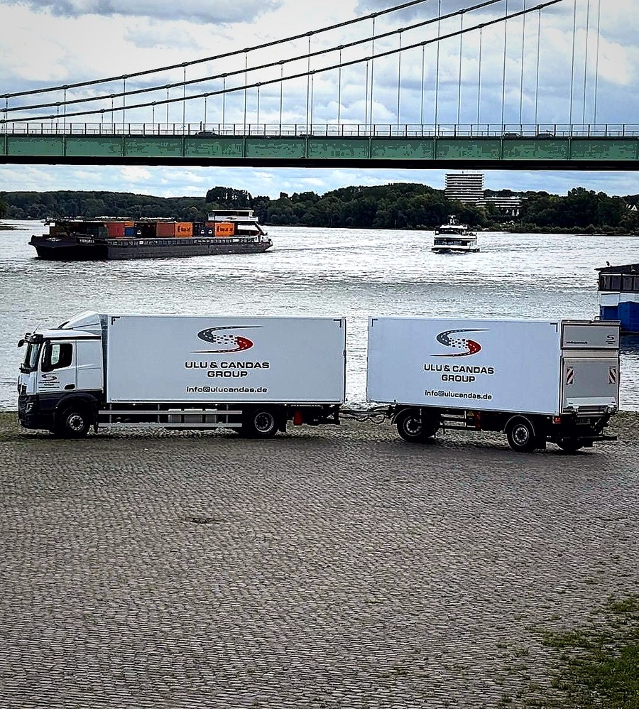Ulu & Candaş Fahrzeug vor Rheinbrücke und Wasser